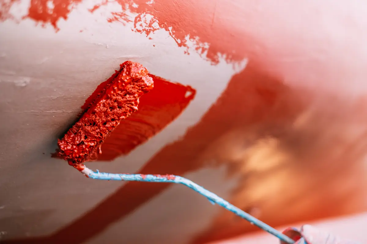 Painting a boat bottom with red paint