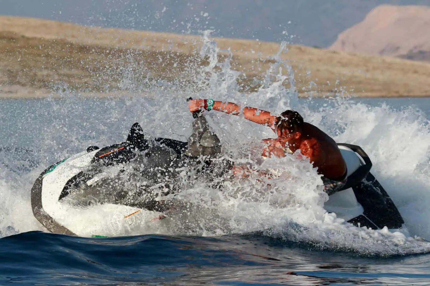 Man riding a jet ski taking a hard turn