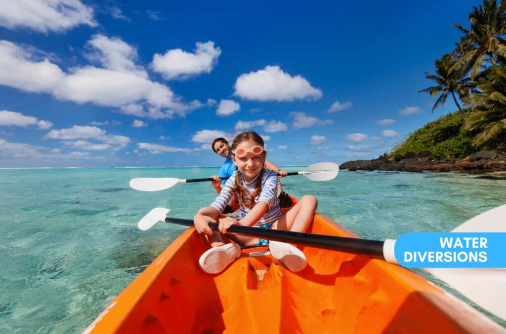 Father and his kid riding in a kayak in clear crystl blue water